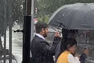 PROLAZNICI SU ZANEMELI PRED PRIZOROM: Stajao je mirno na semaforu na kiši, ljudi nisu mogli da veruju šta drži u ruci! (VIDEO)
